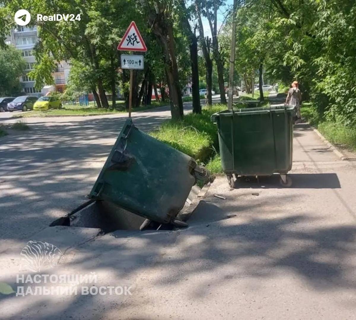 В районе ДОСов провалился асфальт — одну яму закрыли баком, другие контейнеры поставили посреди проезжей части. Из‑за этого мусоровоз не может подъехать, а на жаре отходы источают сильный запах; жители жалуются, но результата нет.