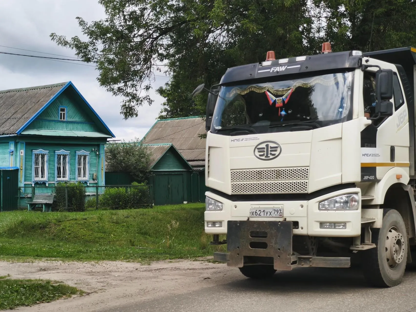 Часть домов уже выкуплена под трассу, другие жители пытаются сохранить жилье и жить рядом с гружёными грузовиками и поездами.